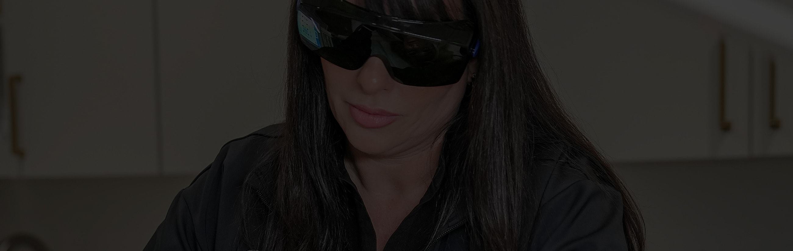 Woman wearing sunglasses, focused on task.