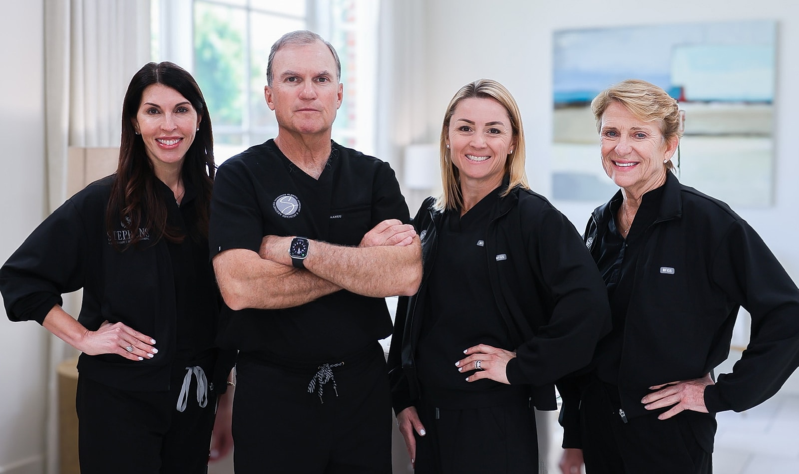 Medical professionals posing in matching black uniforms.