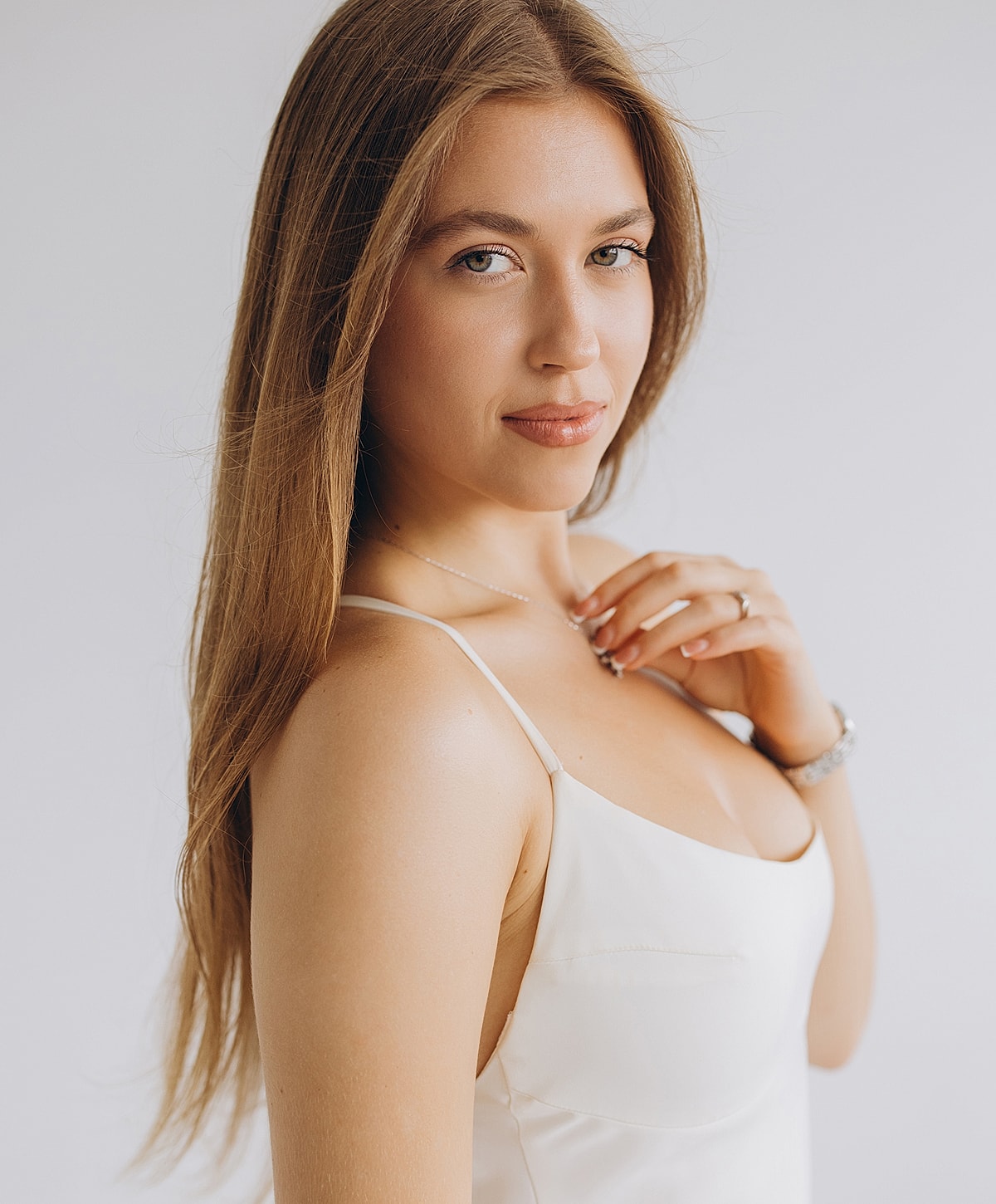 Woman in white dress, long hair, serene expression.
