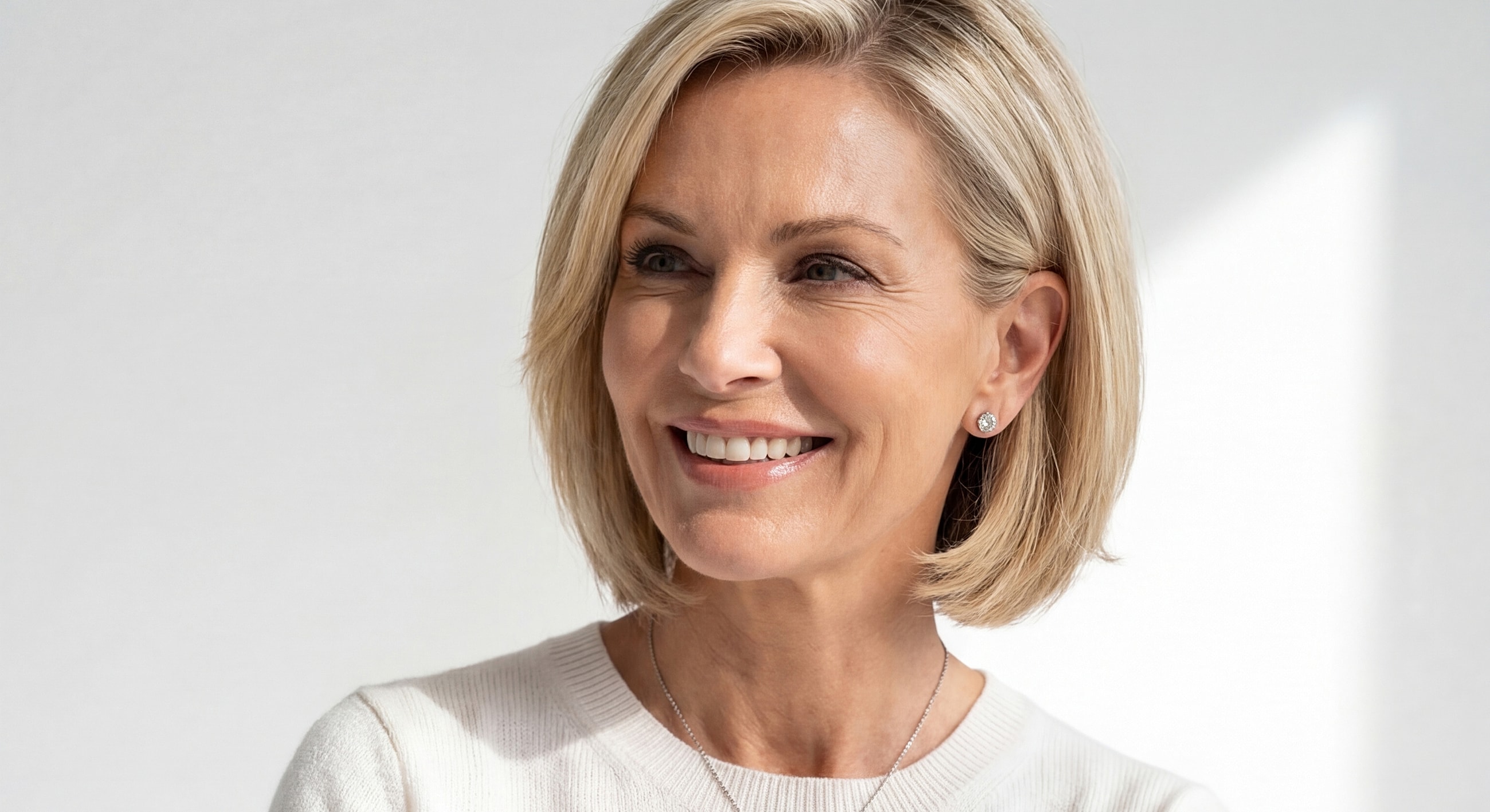 Smiling woman with blonde bob hairstyle.