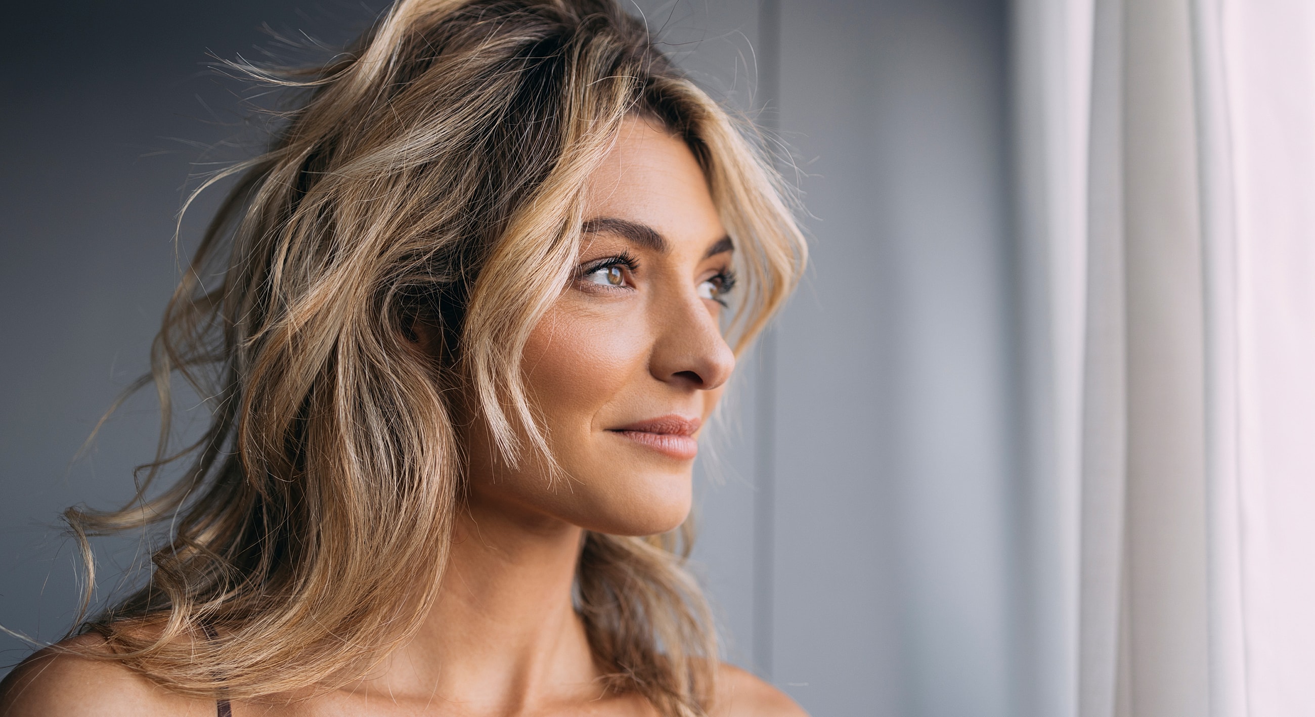 Woman looking thoughtfully out a window.
